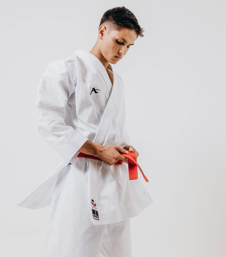 A man in white karate uniform with red belt