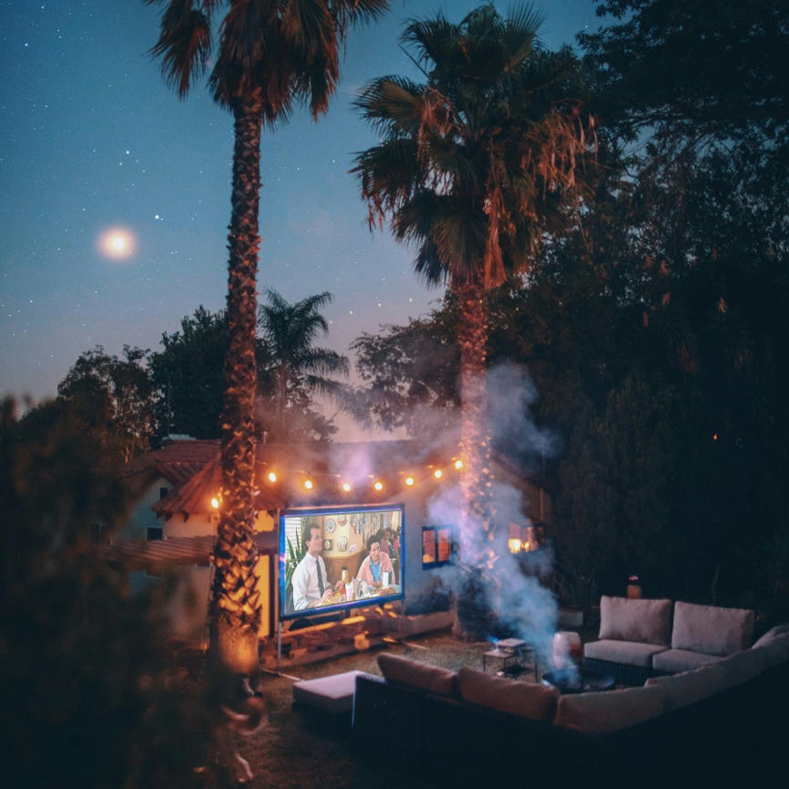 Palm Trees Near Projection Screen during Nighttime